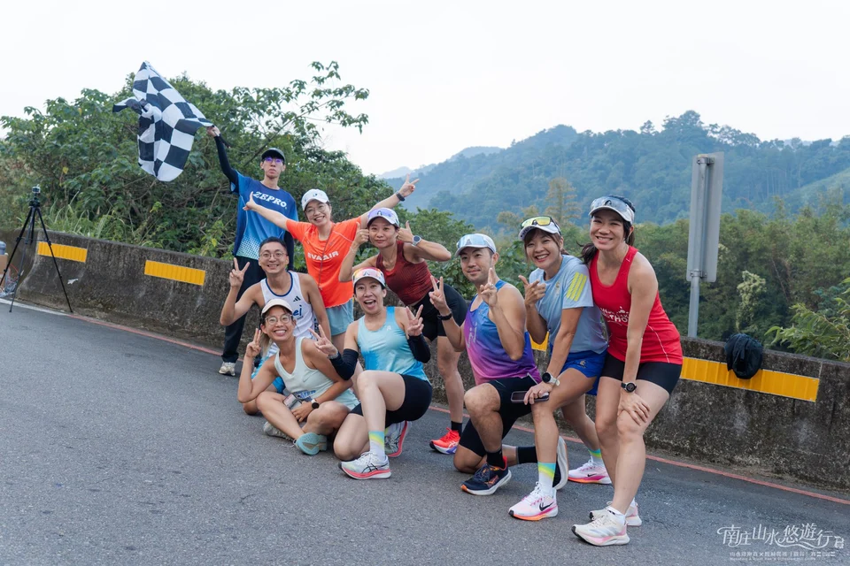 加油團在路邊揮著方格旗合影