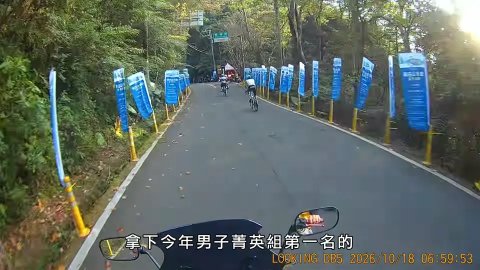 選手騎上兩旁插滿藍色旗幟的終點前山路。